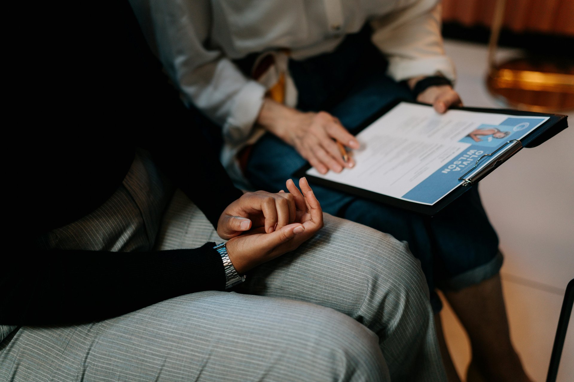 Two professionals reviewing NDIS job description templates and resumes in an office setting