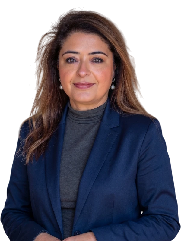 Nishta Trikha wears a navy blazer and dark turtleneck, standing and looking at the camera with a neutral expression.