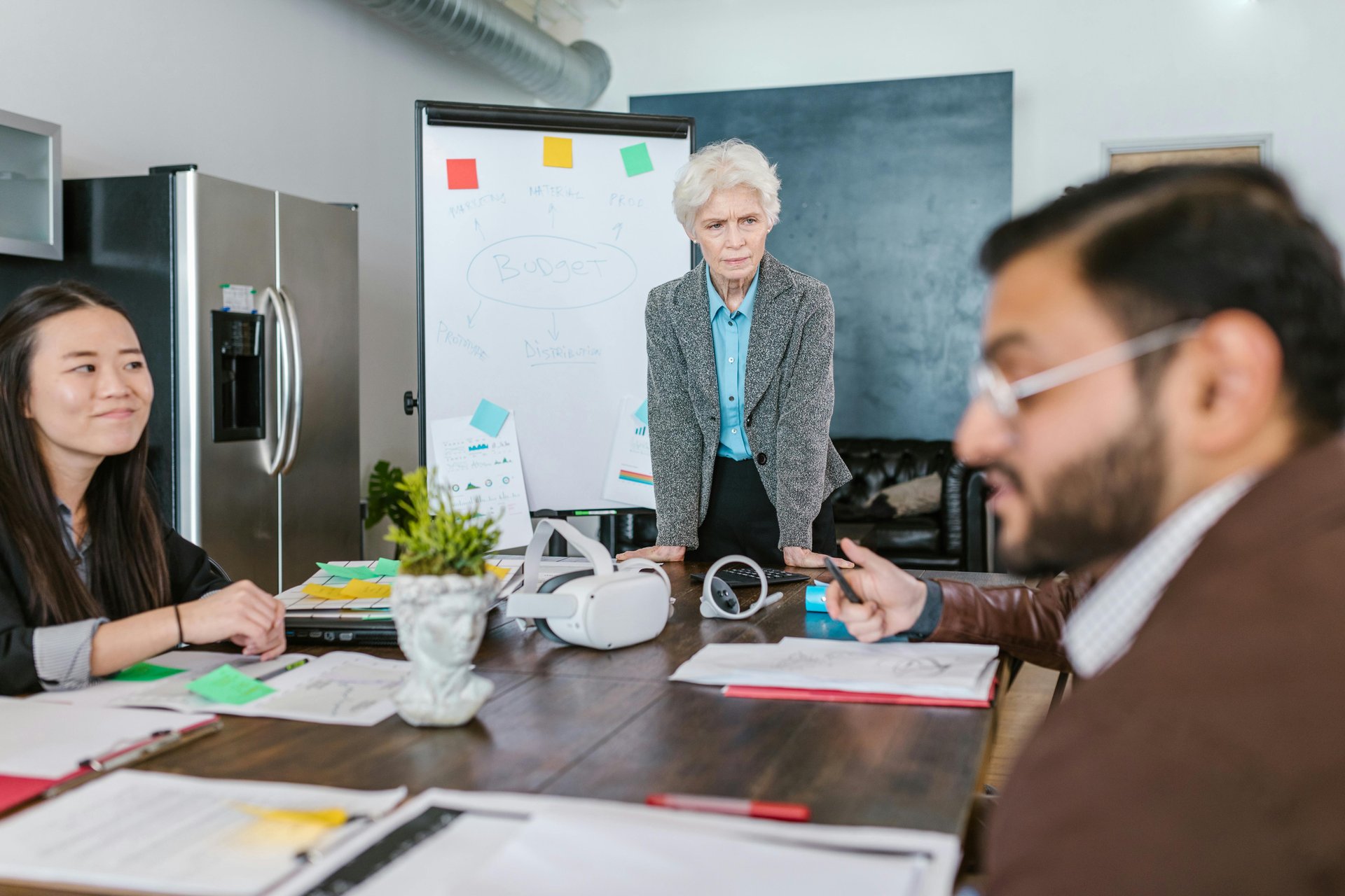 Business professionals collaborating with documents and technology to plan an aged care business model strategy