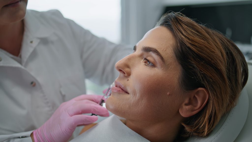 Cosmetic practitioner performing facial injection treatment in a professional clinic