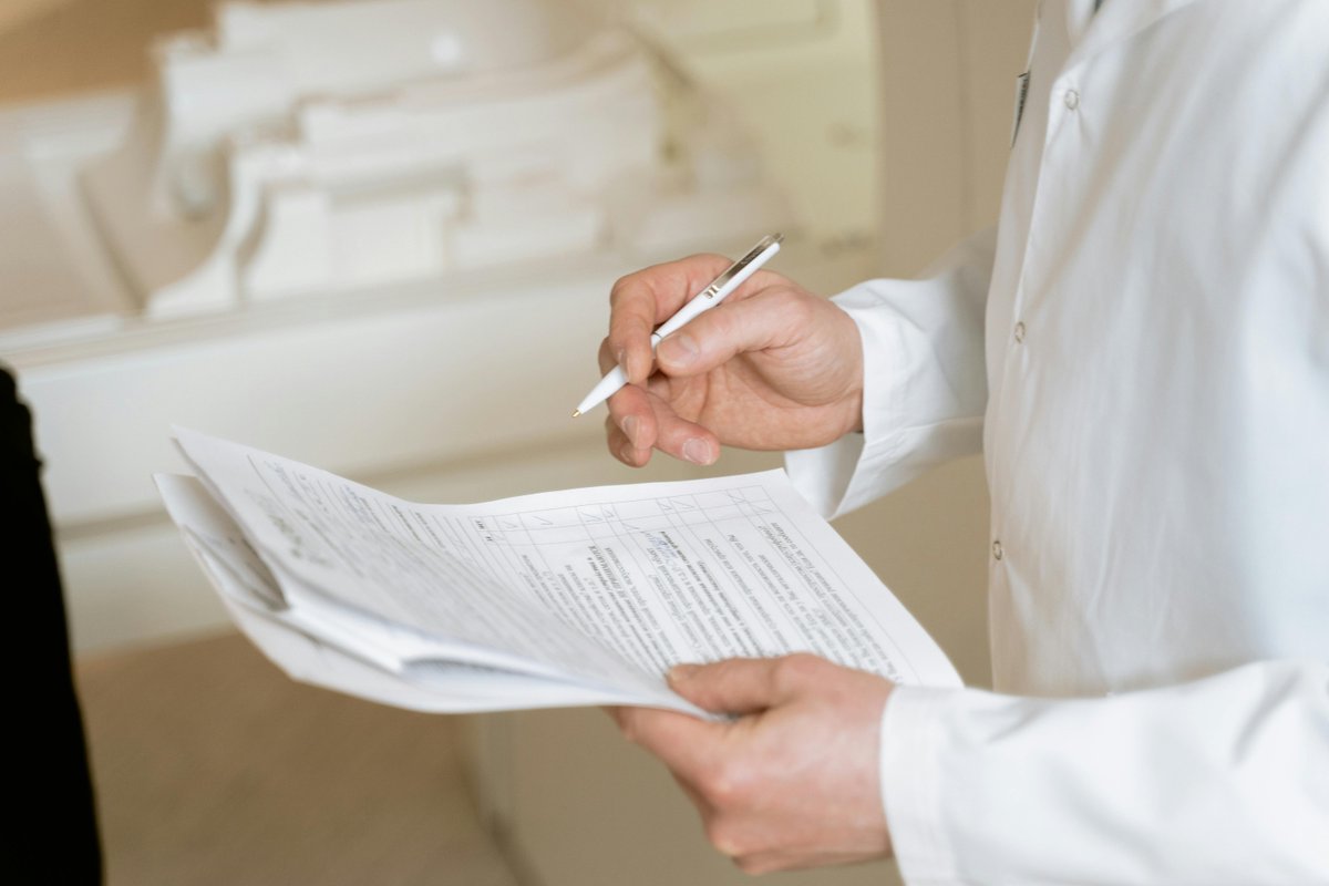 Doctor reviewing medical documents demonstrating careful regulatory compliance examination