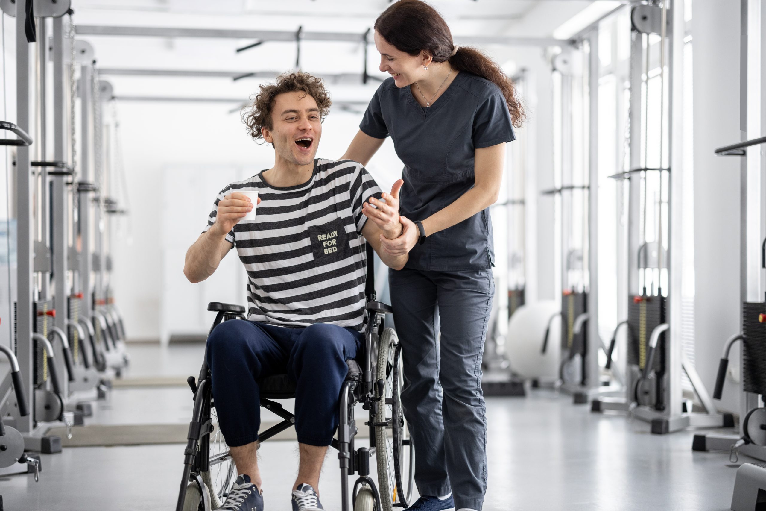 NDIS support worker walking with participant in wheelchair