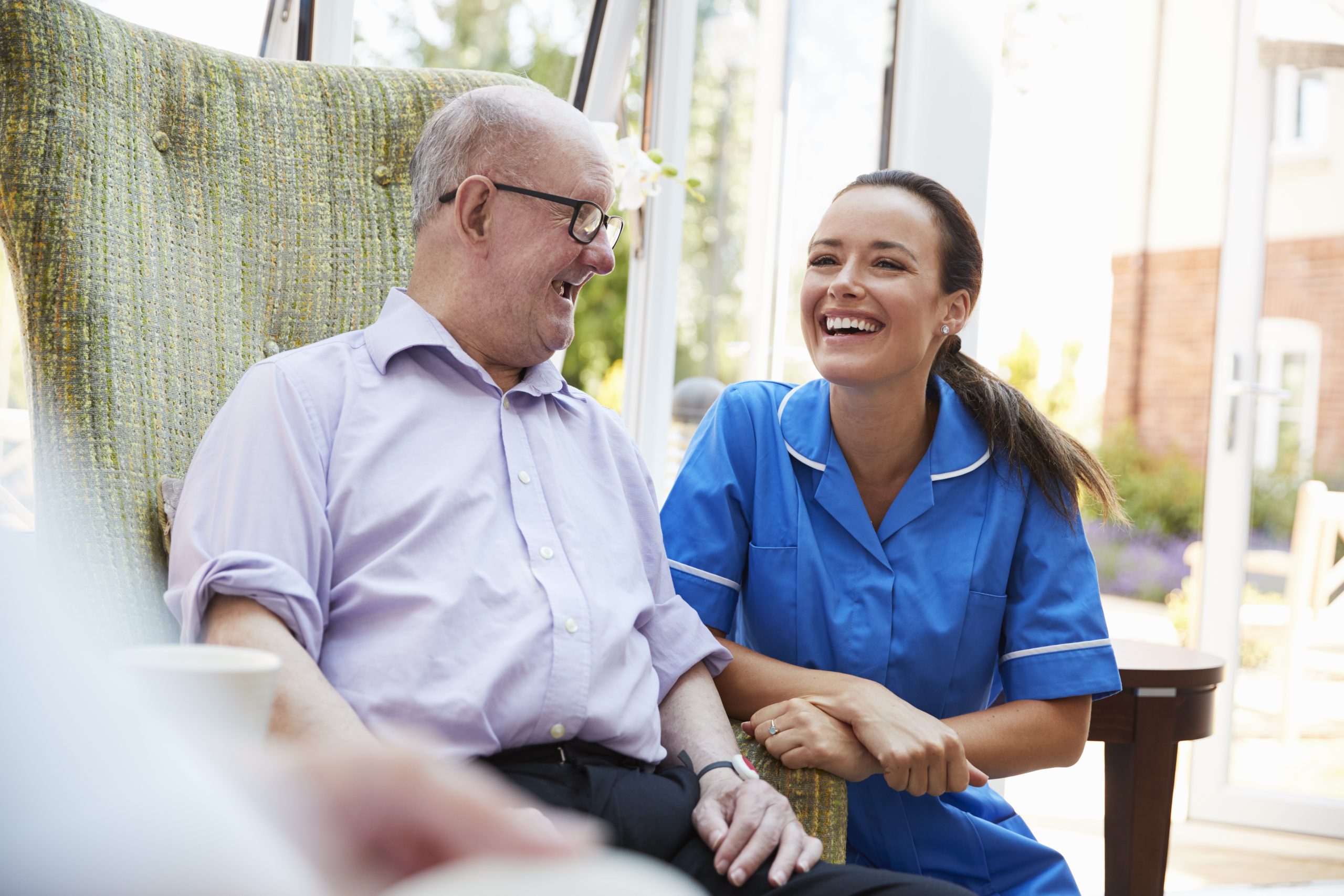 Senior man receiving expert aged care consulting and advisory services from professional nurse