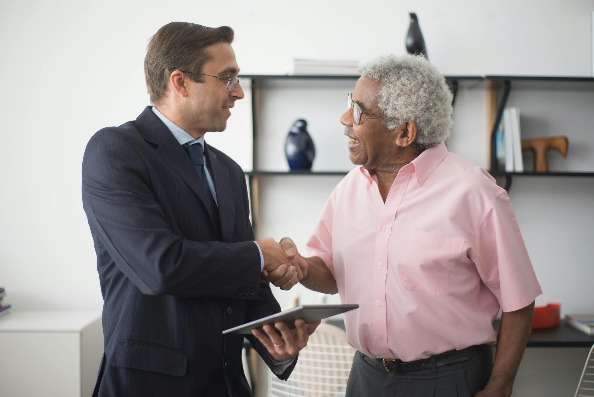 Two business professionals shaking hands representing NDIS provider client acquisition and lead generation strategy